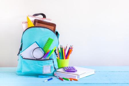 Full turquoise school backpack with stationery on table concept back to school Stock Photo