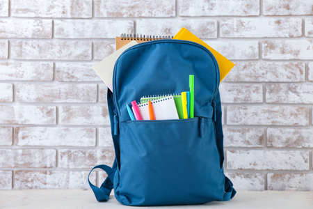 School backpack on table near brick wall