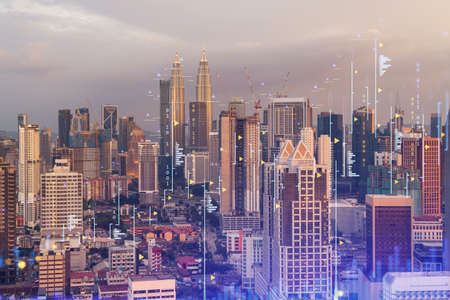 Glowing forex graph hologram aerial panoramic cityscape of kuala lumpur at sunset stock and bond trading in kl malaysia asia the concept of fund management double exposure