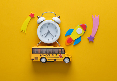 Toy school bus with rocket and alarm clock on a chalkboard back to school education concept