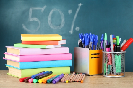 Office supplies on table on school board background