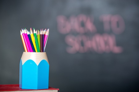 Close up of school books with pencils on desk