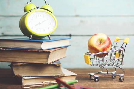 Back to school concept with school supplies and alarm clock