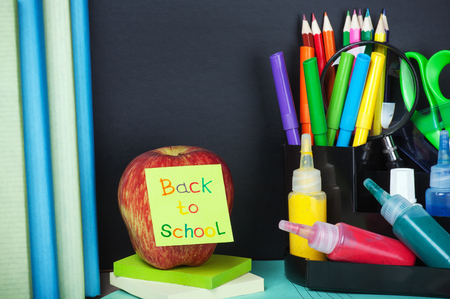 School supplies on the desk in the background of chalkboard Stock Photo