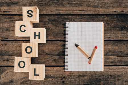 Top view of composition of colorful pencils with blank notebook and word school Stock Photo