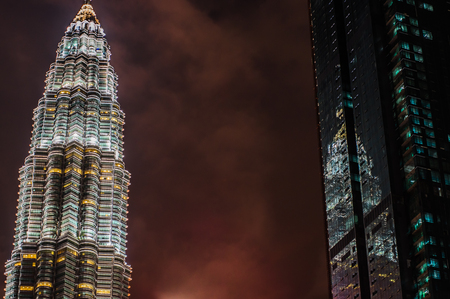 Kuala lumpur by night the most beautiful skyline over the twin towers skyscrapers reflection in the adjoining glass building the beauty of an imperfect perspective